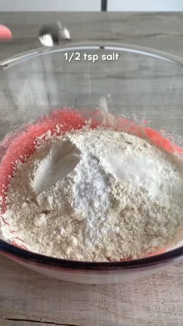 Adding dry ingredients to the strawberry cookie dough: a mix of flour, cornflour, baking powder, baking soda, and salt in a bowl. 