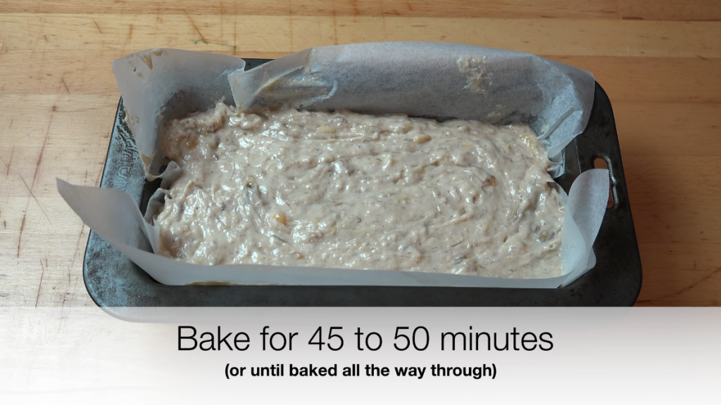 Banana bread batter ready to bake, poured into a parchment-lined loaf pan.