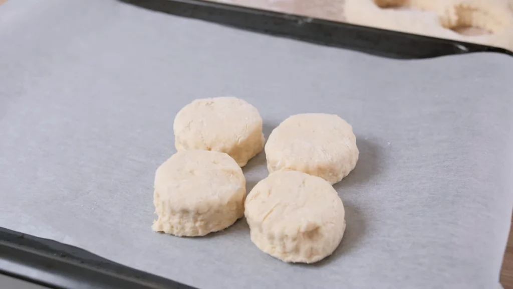 Brushing a thin layer of milk on top of the unbaked scones to ensure a golden-brown finish after baking.